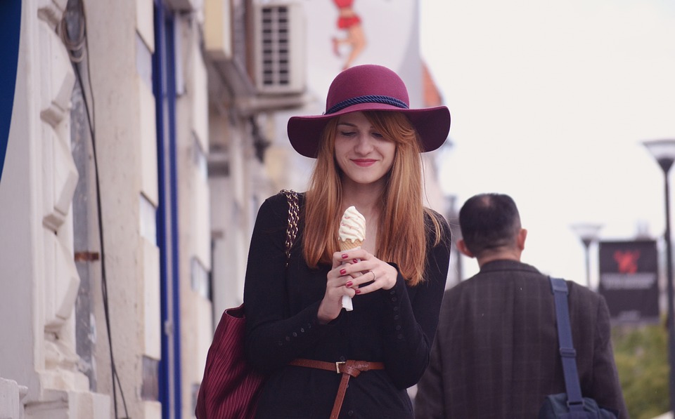 Woman in black holding cone of ice cream
