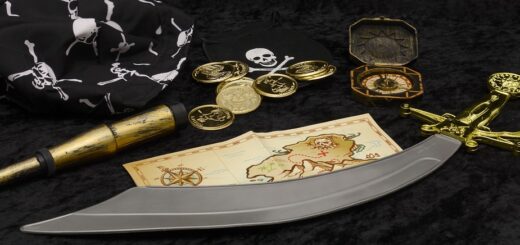 treasure map, sword, compass and other items that represents the history of pirates